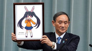 ぷよぷよ風メイベルちゃんの額縁を持ち上げている菅義偉さん